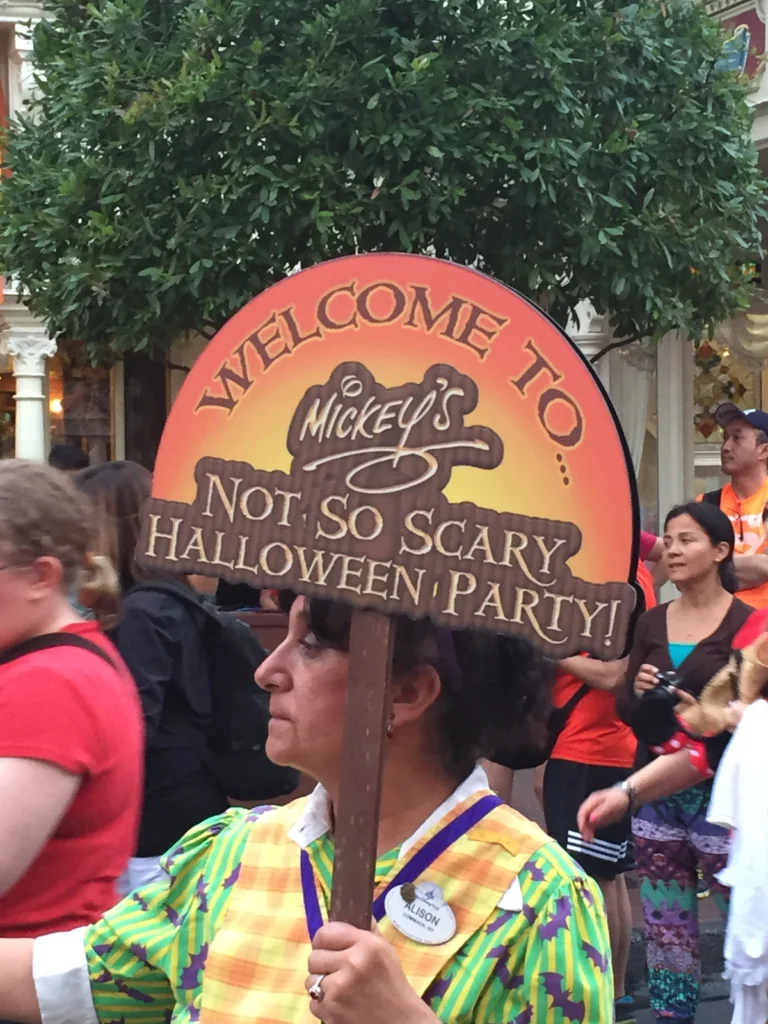 Cast Member with Mickey's Not-So-Scary Halloween Party sign