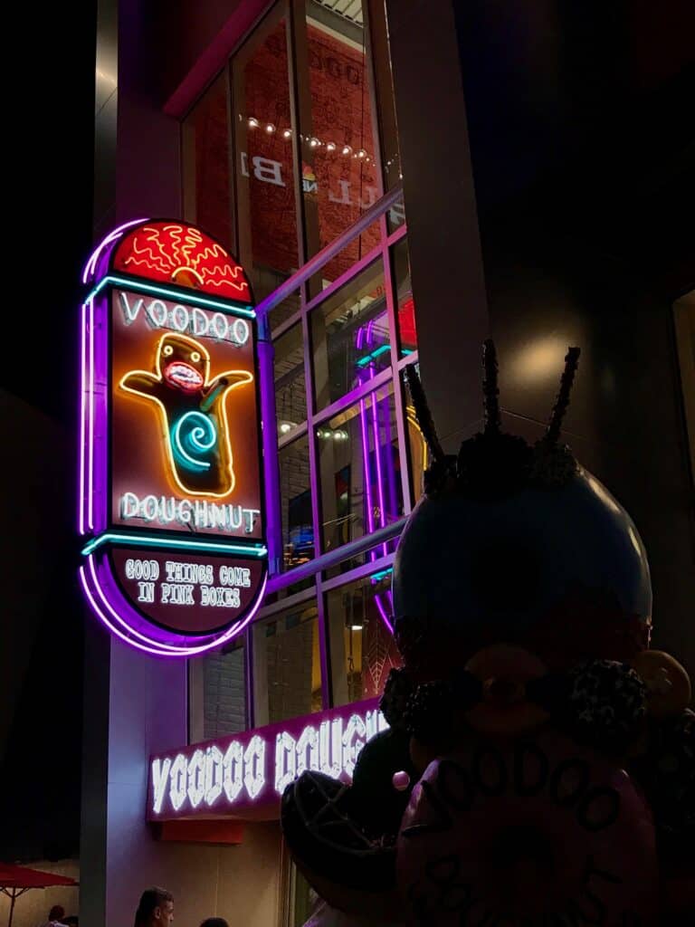Sign for Voodoo Doughnut light up for the evening at Universal Orlando