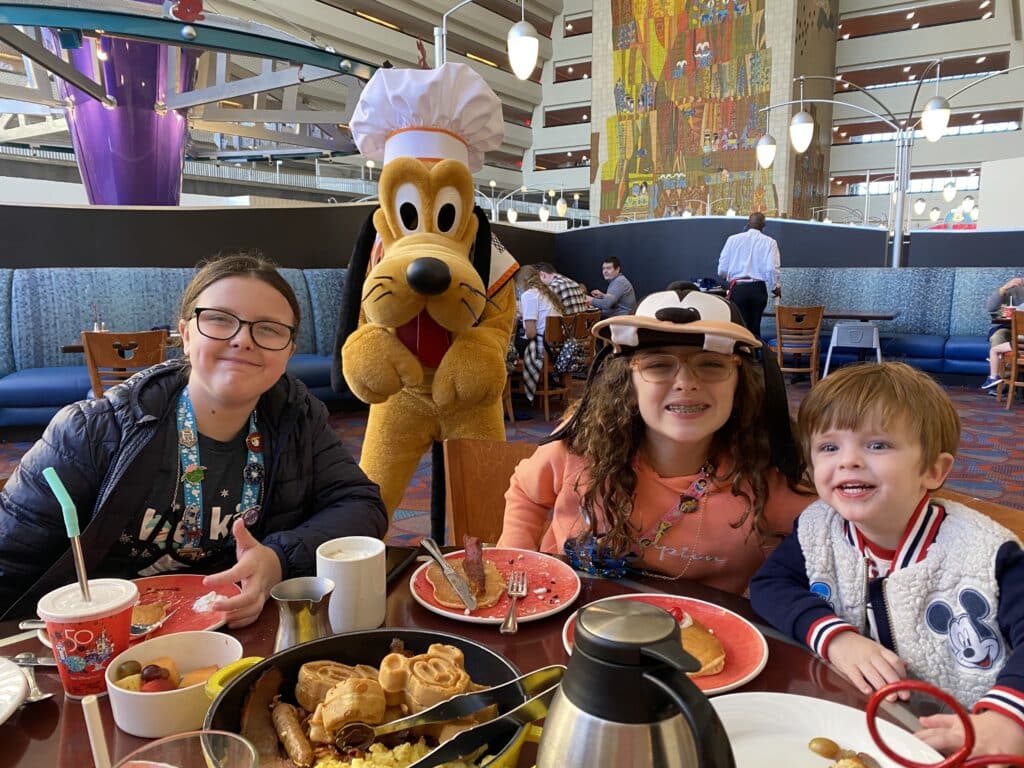Kids meeting Pluto at Chef Mickey's