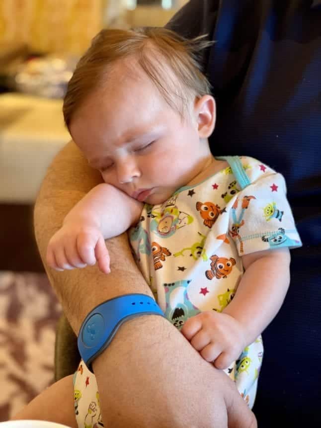 Baby boy sleeping on parent's arm