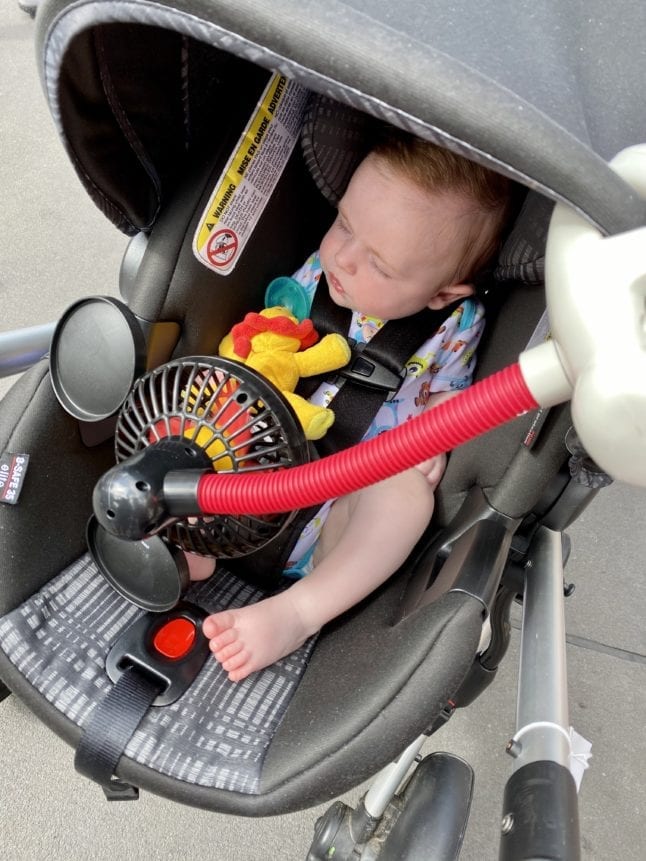 Baby sleeping in stroller with fan